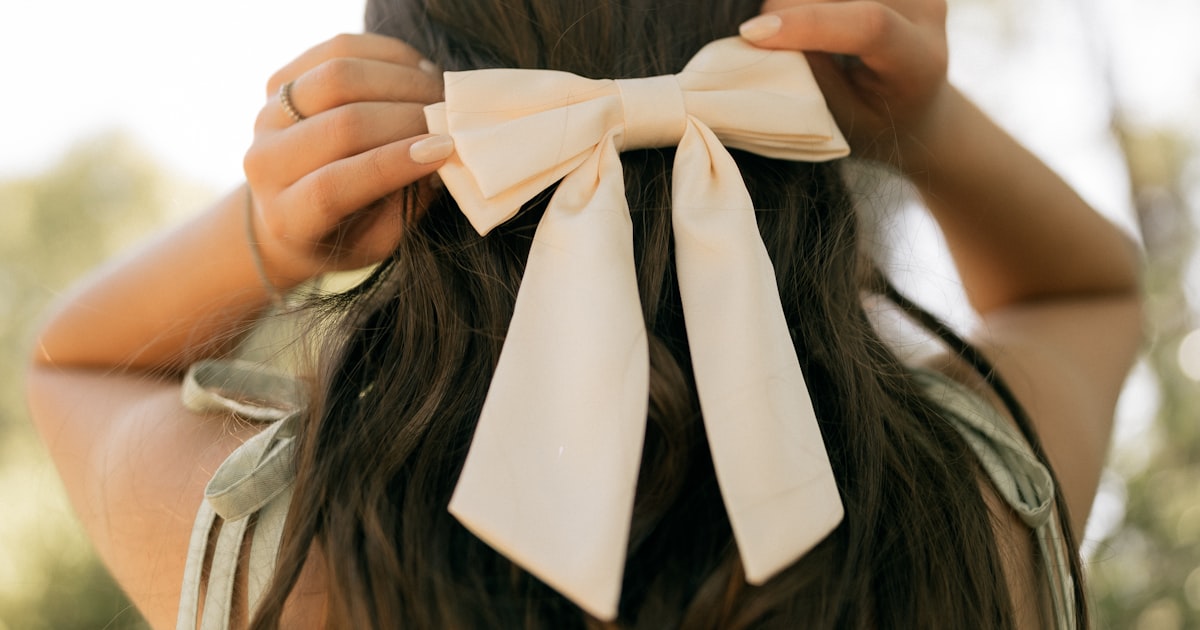 クリーム色のリボンを髪に飾った女性
